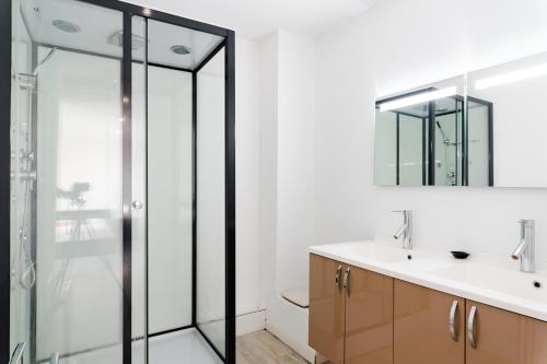 une salle de bain avec une douche en verre et un lavabo dans l'établissement Belle villa avec piscine - Maison de Margaux, à Gruissan