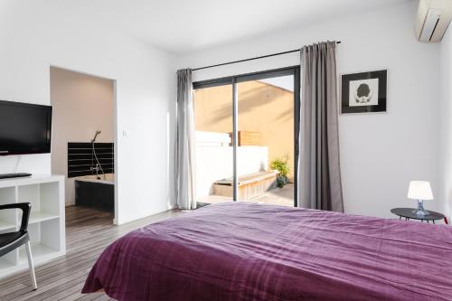 - une chambre avec un lit violet et une porte coulissante en verre dans l'établissement Belle villa avec piscine - Maison de Margaux, à Gruissan