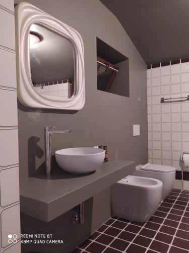 a bathroom with a sink and a toilet and a mirror at Dolomitiloungebelluno Mountain resources in Belluno