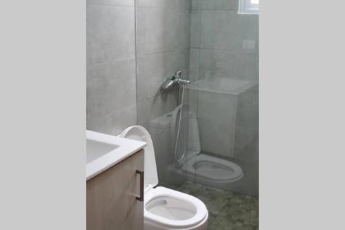 a bathroom with a white toilet and a sink at Hanly Roger's Brand new place in San Felipe de Puerto Plata