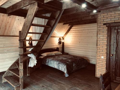 a bedroom with a bed in a room with wooden walls at Загородный отель Слобода, Ясная Поляна, Тула in Samokhvalovka