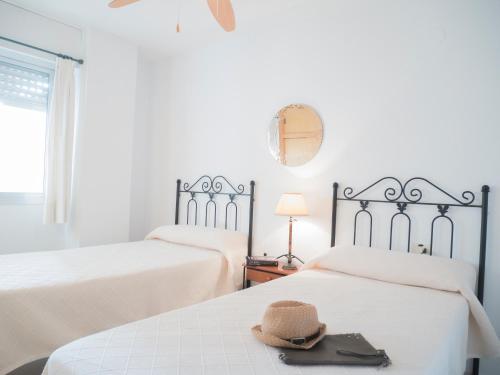 a hat sitting on top of two beds in a room at Apartamentos Irta Playa in Alcossebre