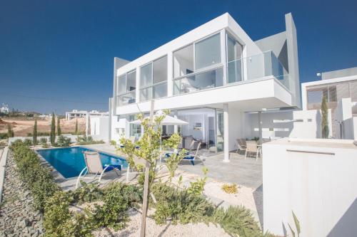 a villa with a swimming pool and a house at Blue Pearl Villas in Protaras