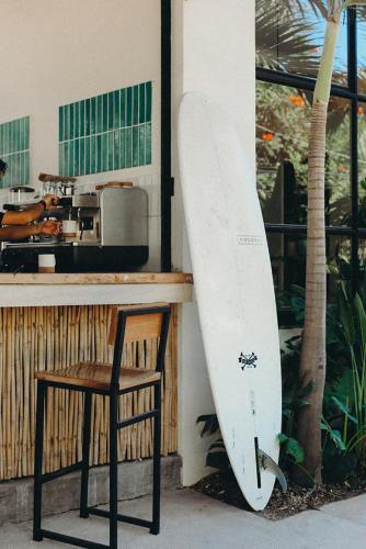 a surfboard leaned up against a counter next to a chair at Residencia Tropical Don Bonito in Sayulita