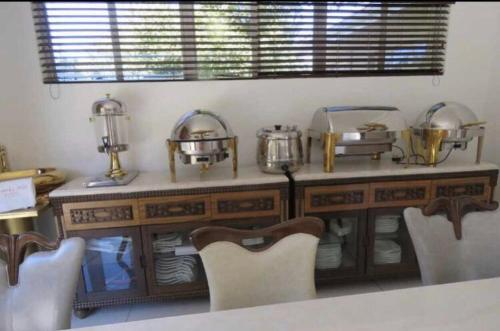 ein Esszimmer mit einem Tisch und Stühlen sowie einer Theke mit Geschirr in der Unterkunft Beverley Hills guesthouse in Queenstown