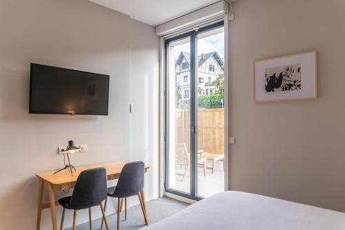 a bedroom with a bed and a table and chairs at Bidaia Boutique Hotel in Donostia-San Sebastián