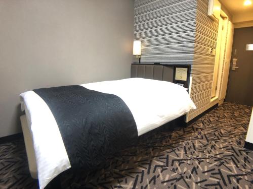 - une chambre avec un grand lit dans l'établissement APA Hotel Machidaeki-Higashi, à Machida