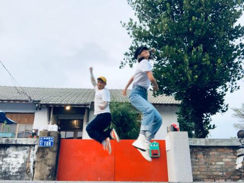 two young men jumping off of a ramp on a skateboard at Here Sleep Guesthouse in Kaohsiung