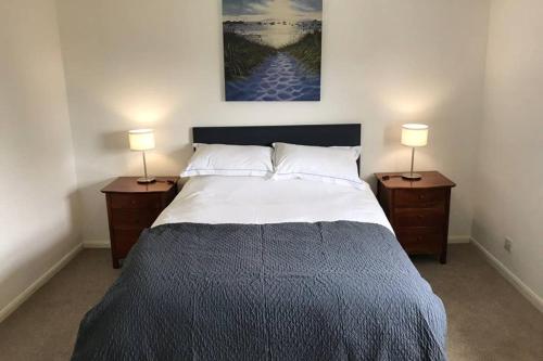 een slaapkamer met een groot bed met 2 nachtkastjes bij Coach House in Weedon