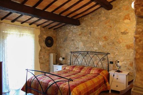 a bedroom with a bed and a stone wall at B&B Fontanelle in Alviano