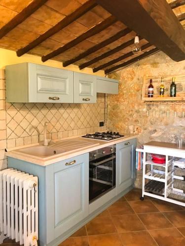 a kitchen with white cabinets and a stove top oven at B&B Fontanelle in Alviano