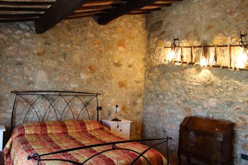 a bedroom with a bed in a stone wall at B&B Fontanelle in Alviano
