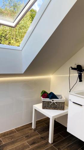 a attic room with a skylight and a white table at Chalupa u Bohumila in Rybná nad Zdobnicí