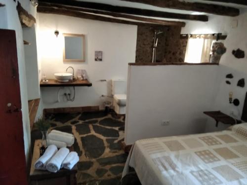 a bathroom with a bed and a sink in a room at Posada Matadero in Cortelazor
