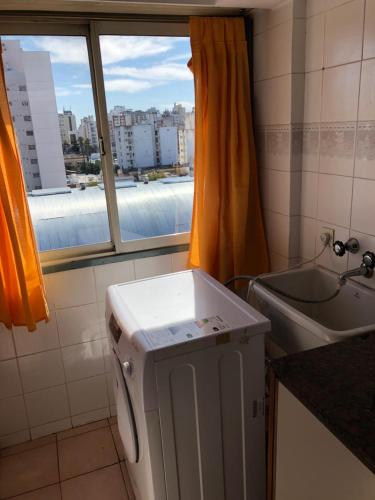 a small refrigerator in a bathroom with a window at Apartamento Pacifico Suites Centro in Bahía Blanca