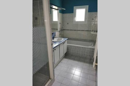 bagno con vasca, lavandino e doccia di Maison 8 personnes à 10 mn Futuroscope a Vendeuvre-du-Poitou