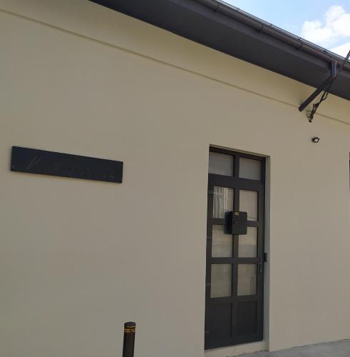 a white building with a window and a black door at Gogol 14 Апартаменти в історичному центрі міста in Uzhhorod