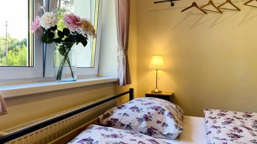 a bedroom with a vase of flowers in a window at Chalupa u Bohumila in Rybná nad Zdobnicí