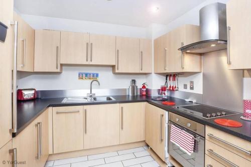 a kitchen with wooden cabinets and a sink at Apartment 12 Popeshead Court in York