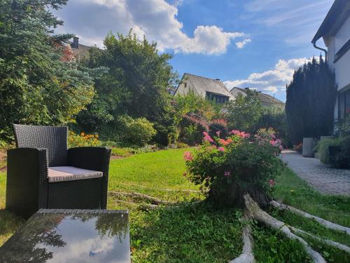 a garden with a chair and flowers in the grass at Moselfeeling co2frei in Cochem