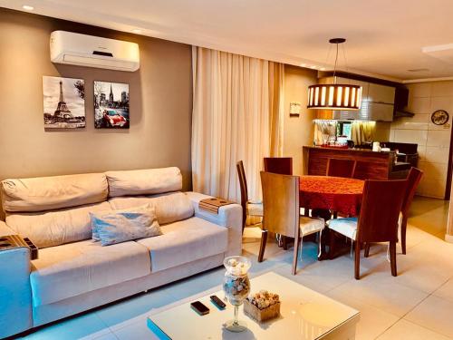 salon z kanapą i jadalnią w obiekcie Bangalô com área de lazer estilo resort w mieście Cabedelo