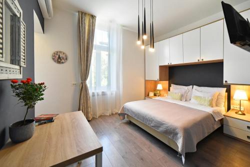 ein Schlafzimmer mit einem großen Bett und einem Tisch in der Unterkunft Time Apartments Downtown in Zagreb