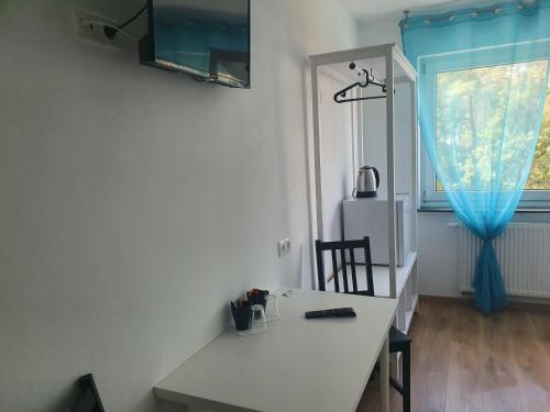 a room with a white table and a blue curtain at Gästehaus am Heuss-Platz in Erlangen