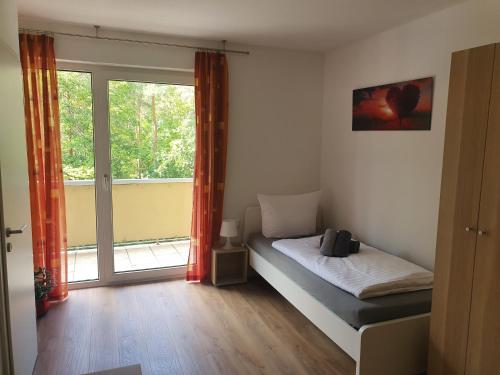 ein Schlafzimmer mit einem Bett und einem großen Fenster in der Unterkunft Gästehaus am Heuss-Platz in Erlangen