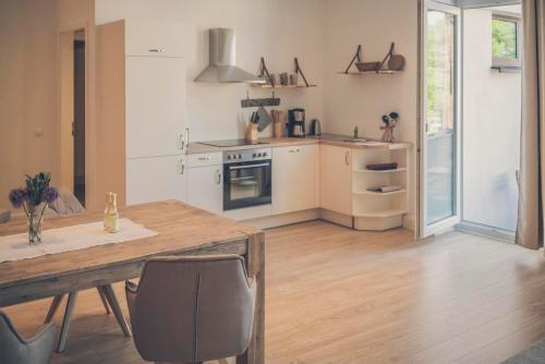 a kitchen with a wooden table and a wooden floor at Stadtblick in Lüneburg