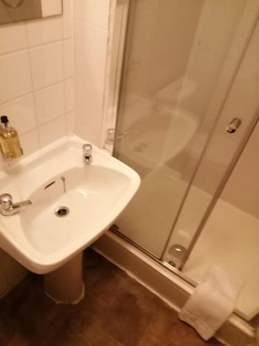 a bathroom with a white sink and a shower at Glasgow House in Glasgow