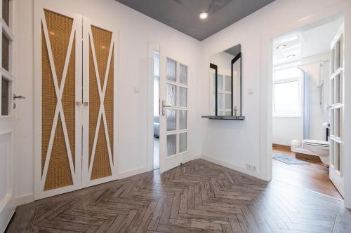 un couloir avec des murs blancs, du parquet et des portes coulissantes dans l'établissement Weitblick-Ferienwohnung, à Eisenach