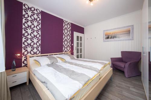 une chambre avec un grand lit et un mur d'accent violet dans l'établissement Weitblick-Ferienwohnung, à Eisenach