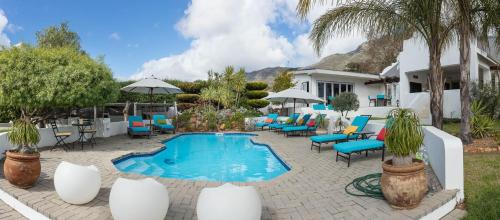 um pátio com piscina e cadeiras e uma casa em Church Hills Boutique Accommodation em Riebeek-Wes