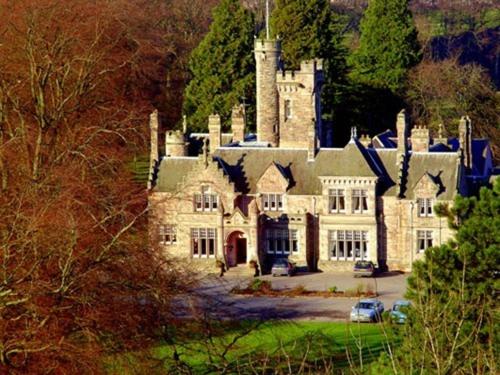 a large stone house with a tower on top of it at Mansion House Hotel in Elgin