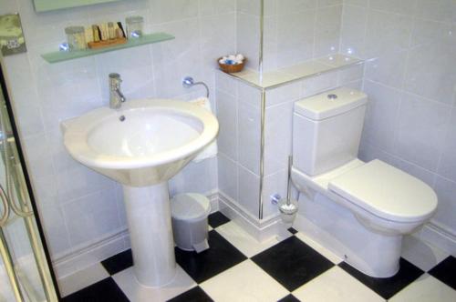 a white bathroom with a sink and a toilet at Mansion House Hotel in Elgin