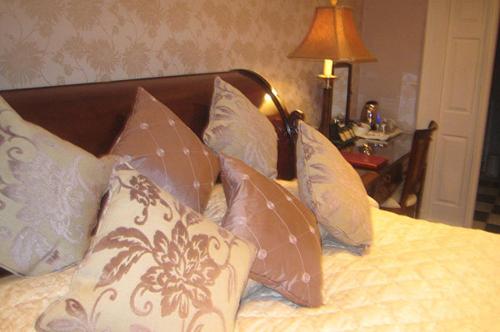 a bed with many pillows on it with a lamp at Mansion House Hotel in Elgin