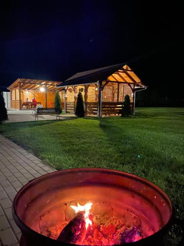 a fire pit with a building in the background at night at Absolut Residence Hateg in Haţeg