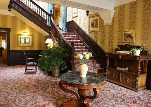 a living room filled with furniture and a staircase at Mansion House Hotel in Elgin