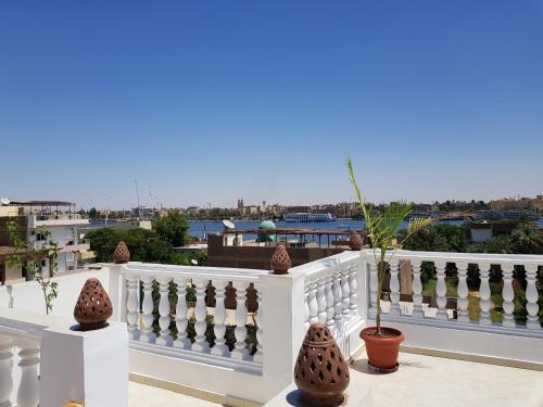 einen weißen Zaun mit Vasen auf dem Balkon in der Unterkunft Luxor VIP Apartments in Luxor