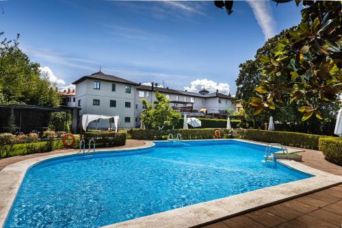 ein Schwimmbad in der Mitte eines Gartens in der Unterkunft Hotel Rio Bidasoa in Hondarribia