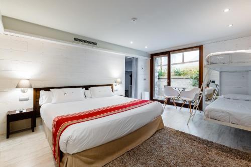 a bedroom with a large bed and a table at Hotel Rio Bidasoa in Hondarribia