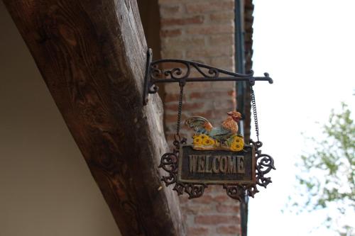 a sign with a chicken on it hanging on a wall at Il Canto Del Gallo B&B in Zenson di Piave
