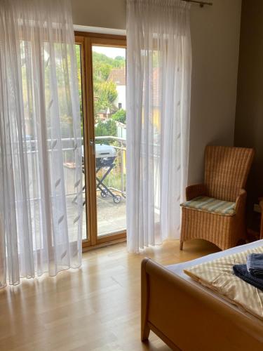 a bedroom with a bed and a chair and a window at Ferienwohnung Kunstmeile in Oberhausen