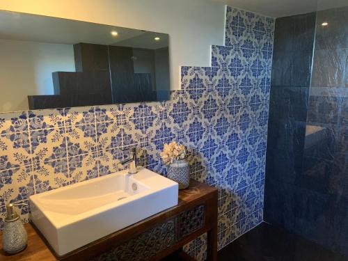 a bathroom with a white sink and blue tiles at Douro Marina Studios in Vila Nova de Gaia