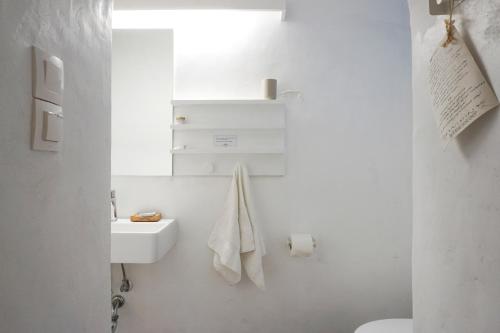a white bathroom with a sink and a toilet at Ghermaniko Guesthouse in Damouchari
