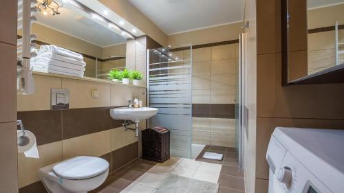 a bathroom with a toilet and a sink and a shower at OLYMPIC PARK Apartament A205 in Kołobrzeg