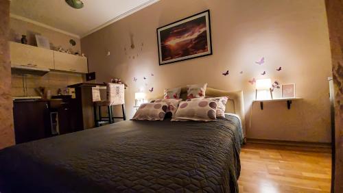 a bedroom with a large bed and a kitchen at Apartman Studio DIAMOND in Subotica