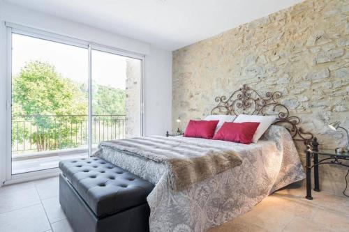 1 dormitorio con 1 cama grande y pared de piedra en Mas des Genêts, en Manosque