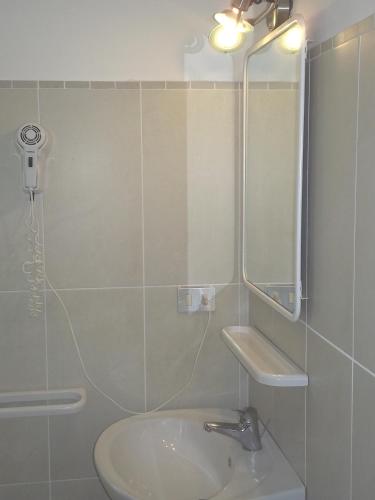 a bathroom with a sink and a mirror at Hotel Magda in Rimini