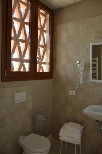 a bathroom with a toilet and a sink and a window at B&B Locanda de' Colli in Signa
